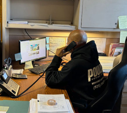 Poulos Moving office worker on the phone at his desk